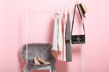 Wall Mural - fashionable clothes on hangers on a wardrobe rack on a colored background.