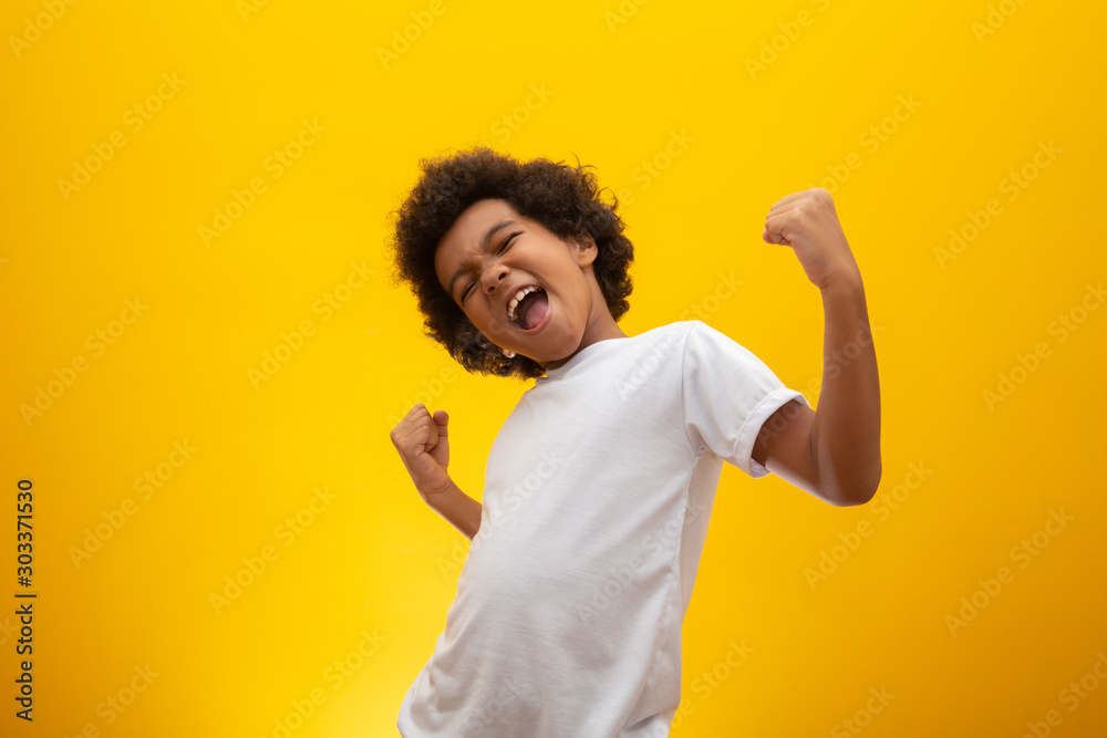 African American boy with black power hair on yellow background. Smiling black kid with a black power hair. Black boy with a black power hair. African descent. - obrazy, fototapety, plakaty 