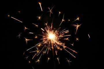 Fire spark xmas with black background. Magic glowing flow of sparks in the dark. Sparkler