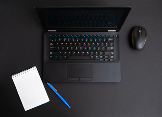 black notebook and black mouse and white note on black desk