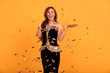 © ClaudiK - Young stylish woman on white background drinking champagne, celebrating new year, wearing black dress. Happy New Year to you. One young and beautiful woman dancing with glass of champagne and smiling
