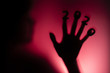 © fantom_rd - silhouette of a female hand with date on fingers pressed to glass of door with a red strange backlight, destruction of the stereotype happy new year, entering 2020 horror genre