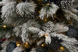 Closeup of branches on an artificial Christmas tree flocked with snow