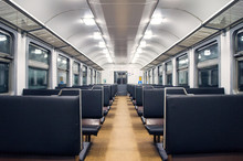 Interior Of An Empty Train Carriage With Metal Shelves And Leather Seats.