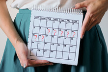 Woman Holding Calender With Marked Missed Period. Unwanted Pregnancy, Woman's Health And Delay In Menstruation.