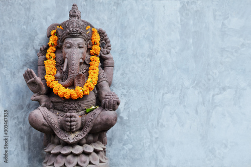 Fotografía Ganesha sitting in meditating yoga pose in front of hindu temple