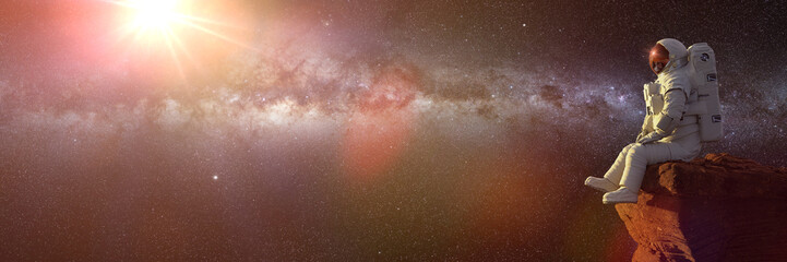 Wall Mural - astronaut sitting on a cliff enjoying the view over an alien world