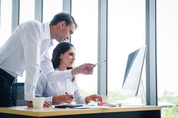 Wall Mural - Senior businessman give advise to another businesswoman on a serious project in office