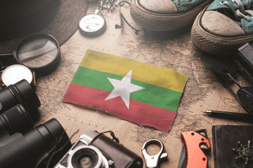 Myanmar Flag Between Traveler's Accessories on Old Vintage Map. Tourist Destination Concept.