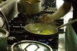 © Natalia - Hand man cooking with a steel pot on the stove in the kitchen