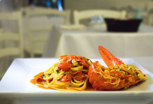 Spaghetti With Lobster And Cherry Tomatoes Served On White Plate