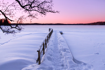 Winter sunset over frozen and snowy lake in Kaarina, Finland.