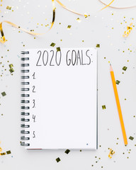 Wall Mural - 2020 goals list in notebook on background with gold confetti
