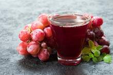 Glass Of Grape Juice And A Branch Of Grapes. Close-up.