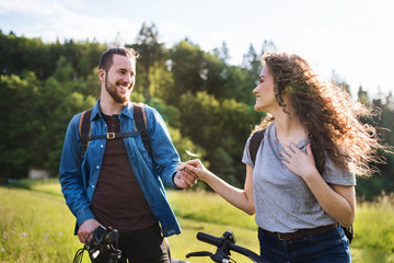Wall Mural - young tourist couple travellers with electric scooters in nature.