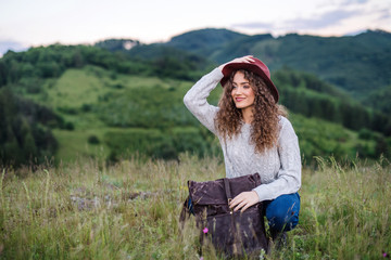 Wall Mural - young tourist woman traveller with backpack in nature, resting.