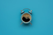 Alarm Clock As Coffee Cup On Blue Background. Top View. Flat Lay. Good Morning Concept
