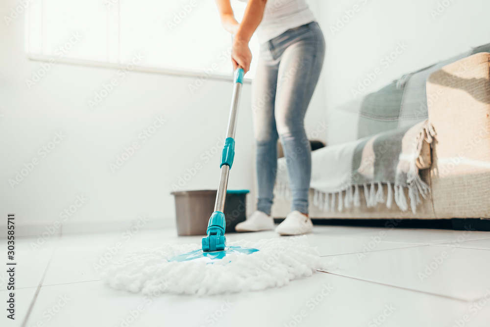 Cropped image of young woman in using a mop while cleaning floor in the house - obrazy, fototapety, plakaty 