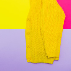 Wall Mural - Fashionable set: part of yellow knitted cardigan on pastel bold background. flat lay