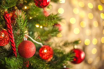 Background from a Christmas tree decorated in red and gold color close-up. Greeting card from a Christmas tree with red decorations and copy space. Details of a decorated Christmas tree with a frame f