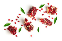 Pomegranate Slices And Green Leaves Isolated On A White Background, Top View
