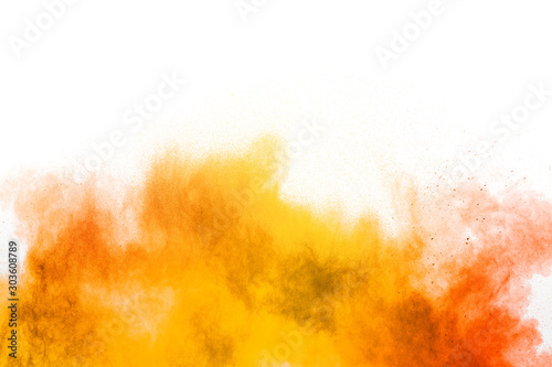 Abstract yellow orange powder explosion on white background. Freeze motion of...