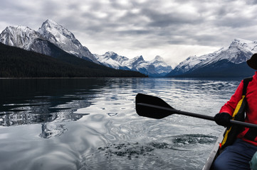 Wall Mural - Red traveler canoeing and rocky mountain in Maligne lake