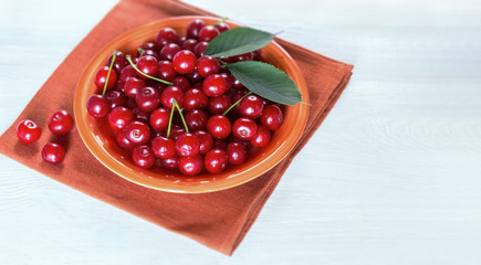 ripe cherries in a plate on the table close-up. background with cherry berries.