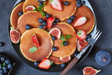 Wall Mural - almond pancakes on a black plate, close-up