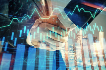 Double exposure of financial chart on cityscape background with two businessmen handshake. Concept of financial analysis and investment opportunities