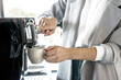 © Supavadee - The female in a suit is making coffee from the coffee machine at workplace.. Having breakfast in the morning