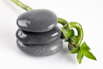 Composition Spa for beauty salons. Bamboo and dark gray stones on white background.