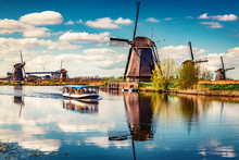 Walking Boat On The Famoust Kinderdijk Canal With Windmills. Old Dutch Village Kinderdijk, UNESCO World Heritage Site. Netherlands, Europe.