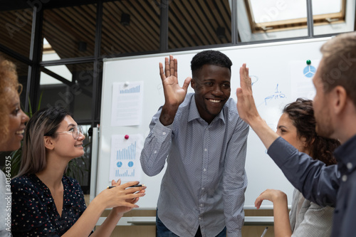 Fotomural Happy african american team leader giving high five to partner.