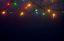 Christmas Lights On Blue Background With Copy Space.