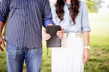 Closeup shot of couple both holding the bible with a blurred background