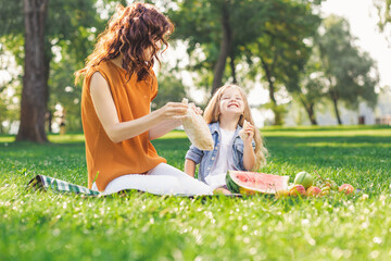 Wall Mural - girl and woman having picnic in the park together