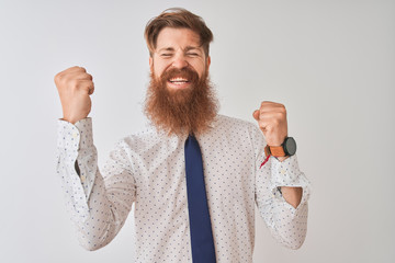 Sticker - Young redhead irish businessman standing over isolated white background celebrating surprised and amazed for success with arms raised and eyes closed. Winner concept.