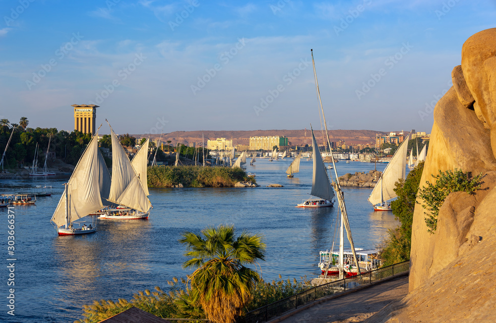 Beautiful landscape with felucca boats on Nile river in Aswan at sunset, Egypt - obrazy, fototapety, plakaty 