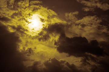 sun behind dark yellow clouds