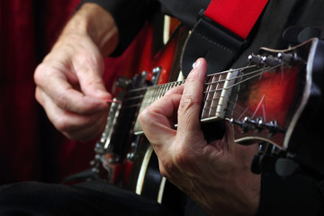 Wall Mural - Guitarist hands and guitar close up. playing electric guitar.