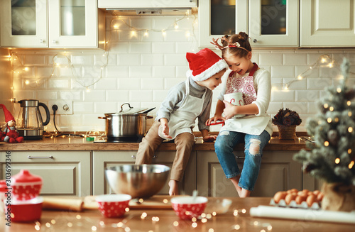 Cuadros en Lienzo happy children boy and girl bake christmas cookies