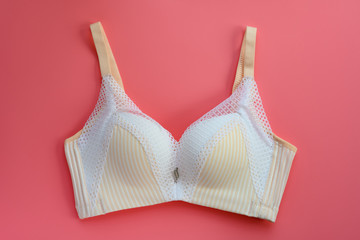 Wall Mural - white and light yellow bra for women on a pink background