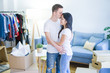 © Krakenimages.com - Young beautiful couple hugging at new home around cardboard boxes