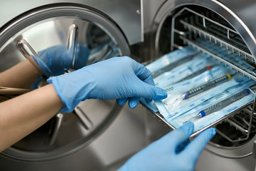 Doctor is taking dental probe from sterilize machine