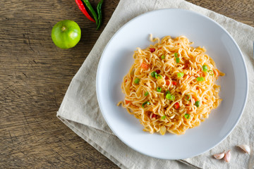 A cup of instant noodles placed on a napery With chilli as ingredients ,top view noodle and copy space