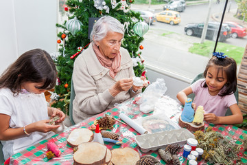 Grandmother teaching her granddaughters how to make christmas Nativity crafts - Real family