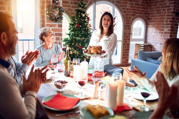 Family and friends dining at home celebrating christmas eve with traditional food and decoration, showing proud turkey cooking