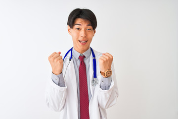 Chinese doctor man wearing coat tie and stethoscope over isolated white background celebrating surprised and amazed for success with arms raised and open eyes. Winner concept.