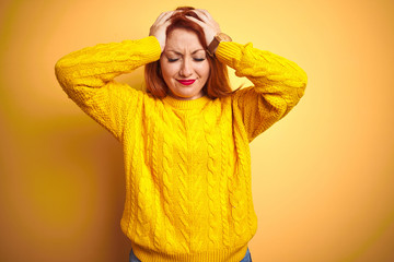 Canvas Print - Beautiful redhead woman wearing winter sweater standing over isolated yellow background suffering from headache desperate and stressed because pain and migraine. Hands on head.